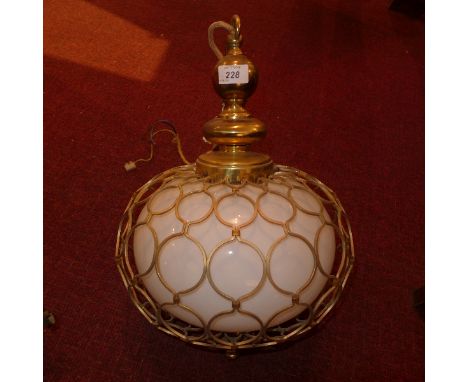 A modern ceiling light having opaque glass bulbous centre within netted brass design