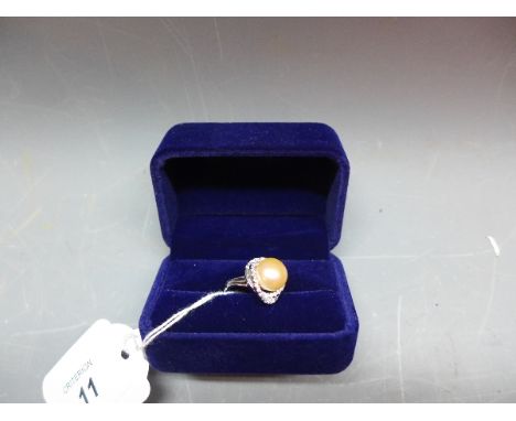 A ladies white metal ring with pearl to centre flanked by faux stones. Size 'N'