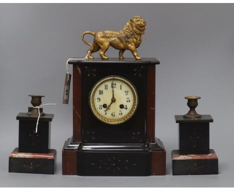 A rouge and black marble clock garniture, the clock of architectural form with enamelled Arabic dial and gilt lion surmount, 