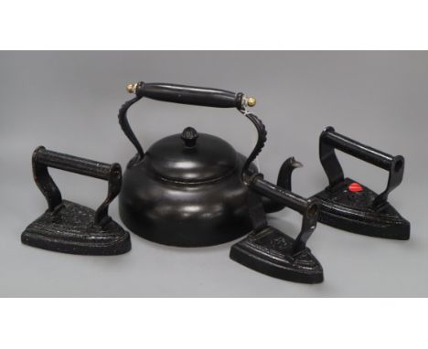 A set of three Victorian brass and iron horse door stops, an iron kettle and three irons