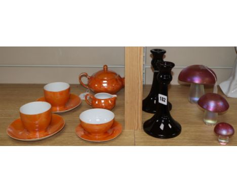 A graduated set of three iridescent glass mushrooms, a pair of amethyst glass candlesticks and a Czech orange lustre tete-a-t