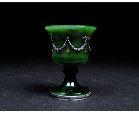 A Faberge nephrite jade cup, 20th century, the bell shape bowl with applied silver swags tied with ribbons and gem set, on a 