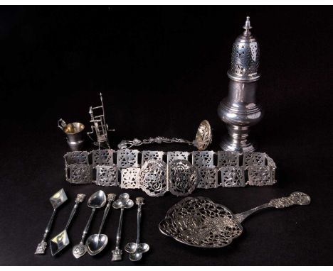 A mixed group of silver items, comprising a sugar sifter, a belt, playing card themed spoons, two sifting spoons, a miniature