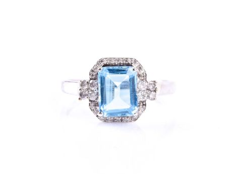 A 9ct white gold, diamond, and blue topaz cocktail ring, set with a mixed rectangular-cut topaz, measuring approximately 8 x 