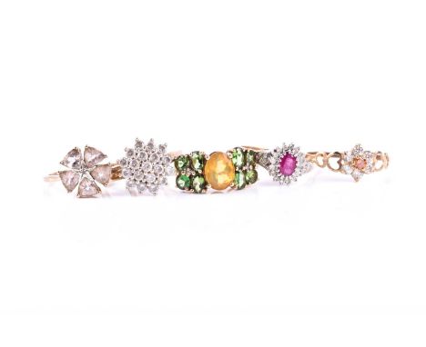 A ruby and diamond cluster ring, the oval cut ruby, within a brilliant cut diamond border, diamond set shoulders and 9ct gold