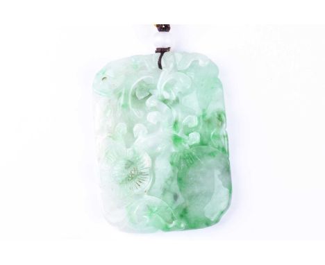 A carved jade pendant, the rounded rectangular panel carved and pierced with layered fruiting and blossoming foliage, with wh