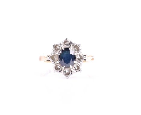 A sapphire and diamond cluster ring, the central oval cut blue sapphire within a border of eight round brilliant cut diamonds