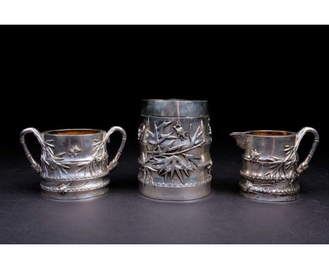 A Chinese silver tea caddy, sugar bowl and cream jug by Luen Wo, 19th century, each of bamboo form with relief cast insects a