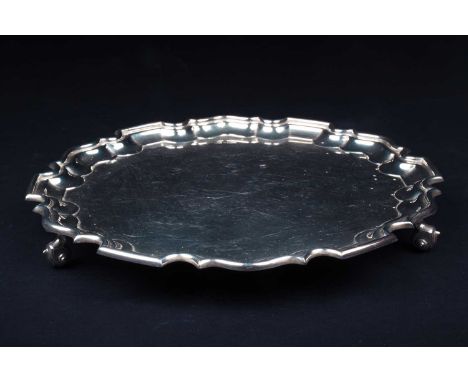 A mid-20th century silver salver, Sheffield 1958 by Walker &amp; Hall, of scalloped edge form on three scrolled feet, 31.5 cm