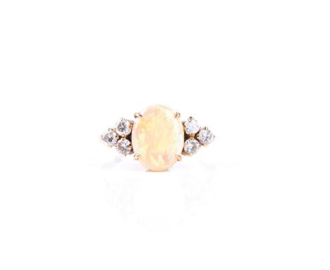 An 18ct yellow gold, diamond, and opal ring, centred with an oval cabochon opal, approximately 11 x 8 mm, flanked with six ro