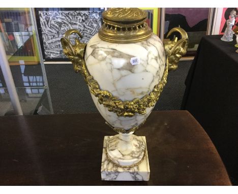 A pair of marble lamp stands with brass swag and goat decoration.