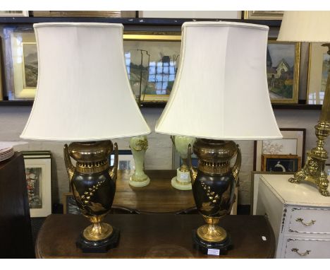 A pair of brass and bronzed twin handle vases with oil lamp reservoir conversions.
