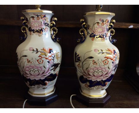 A pair of lamp stands with painted and gilt floral design.