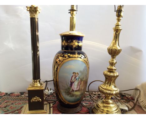 Three lamp stands, one glazed blue white and gilt and two brass in Classical style design.