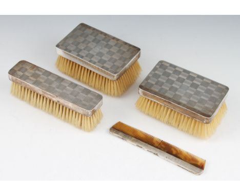 An Art Deco four piece dressing table set, comprising of three hand brushes and a comb, all featuring geometric design and en