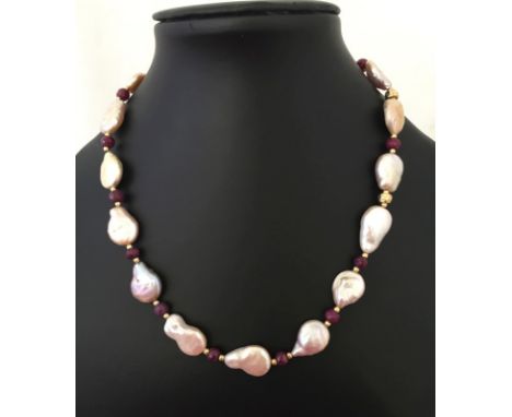 A boxed Pia freshwater pearl & ruby single strand necklace. Made up of large 'potato' freshwater pearls, interspersed with na