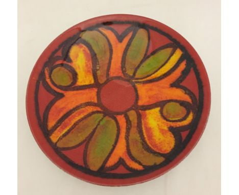 A Poole pottery "Delphis" plate, in red, orange and green tones.  Approx. 20½cm diameter.