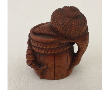 A wooden carved netsuke of snails on a barrel. Character marks on base. Approx. 4cm tall.