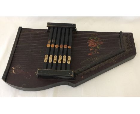 A vintage Auto Harp decorated with roses. Comes with tuning key. Measures approx 45cm x 25cm.