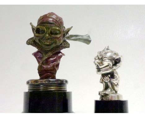 To include -
1. A rare cold-patinated bronze WW1 'Aviator Gnome' Mascot, offered on a large period radiator cap and display b