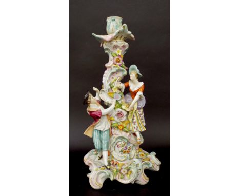 Sitzendorf German porcelain figural candlestick decorated with a young lady and her suitor and various flower encrustations, 