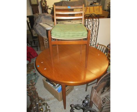 A mid century retro extending dining table of circular form with raising butterfly leaf, on tapering round legs, 74h x 121cm 