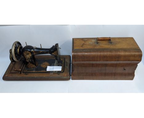 A Jones manual sewing machine in a walnut carrying caseLocation: 