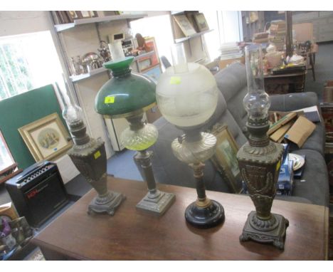 A group of four early 20th century oil lamps to include a pair of Matador brass lamps with applied coat of arms, and glass sm