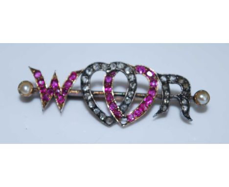A Victorian yellow and white metal, ruby and diamond sweetheart brooch, with the letters W and R and two entwined hearts set 