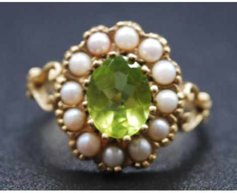 A 9ct yellow gold, peridot and pearl oval cluster ring, comprising a centre oval peridot within a border of twelve 2.7mm pear
