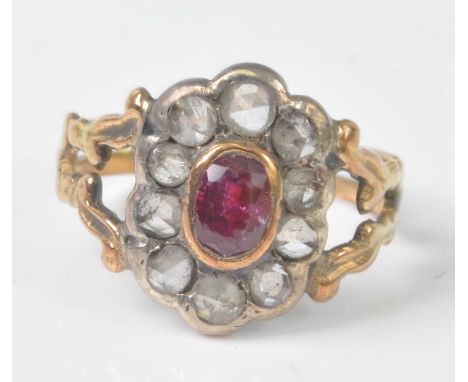 A yellow and white metal, ruby and diamond oval cluster ring, featuring a centre oval faceted ruby within a border of ten ros