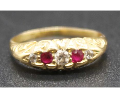 An 18ct gold ruby and diamond five stone ring, the alternating graduated round cut stones in a carved line setting, total dia