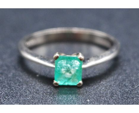 An 18ct white gold emerald single stone ring, comprising a rectangular cut emerald in a four claw setting, emerald dimensions