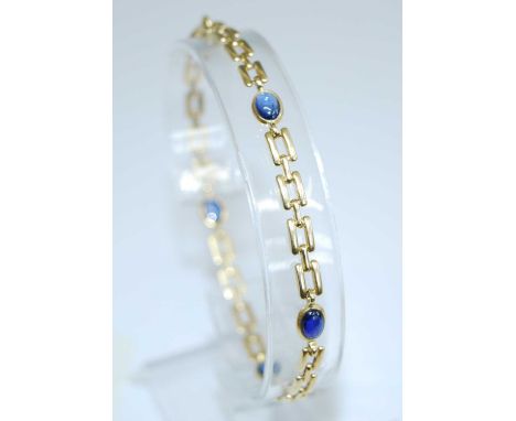 A yellow metal sapphire bracelet, comprising four oval sapphire cabochons in bezel settings, with two bar gate link detail an