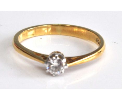 An 18ct yellow and white gold diamond single stone ring, featuring a round brilliant cut diamond in an eight-claw setting wit