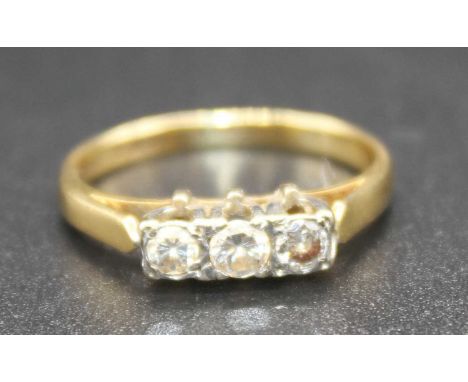 An Art Deco 18ct gold diamond three stone ring, the round cuts in a raised white metal line setting, total diamond weight est