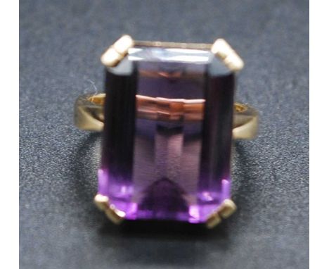 A modern 18ct gold amethyst set dress ring, the four-claw set emerald cut amethyst measuring approx 18.5 x 14 x 8mm, to a pla