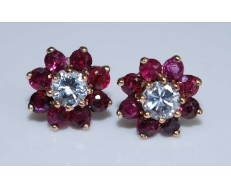 A pair of yellow metal, ruby and white sapphire flower shaped cluster earrings, each with a centre 2.7mm white sapphire surro