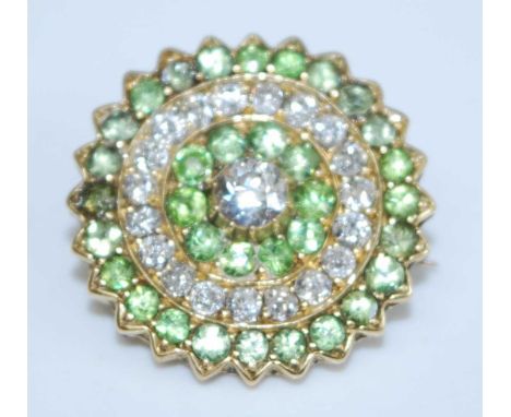 A yellow metal, peridot and diamond circular cluster brooch, featuring a centre Old European cut diamond within a border of t