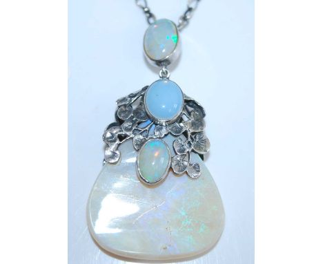 A white metal Art Nouveau style opal pendant, featuring three graduated oval opal cabochons in closed back bezel settings wit