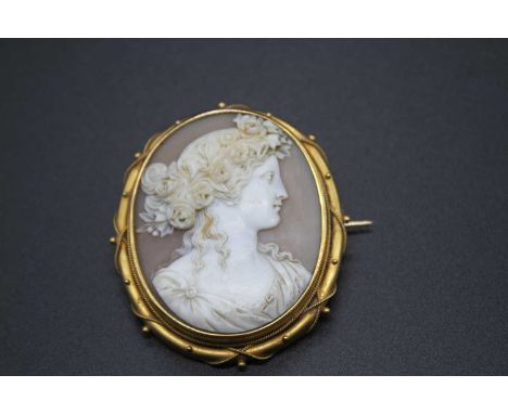 A late 19th century carved shell cameo brooch depicting profile portrait of a maiden wearing flowers in her hair, 45x37mm, th