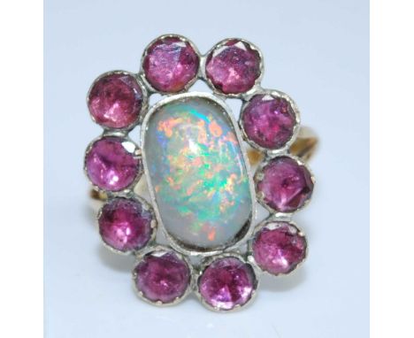 A late Victorian 18ct yellow gold, opal and garnet oval cluster ring, comprising a 12.55 x 7.7mm oblong opal cabochon within 