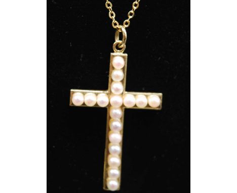A yellow metal pearl set cross pendant, featuring seventeen 2.5mm cultured Akoya pearls, length 30mm, attached to a trace lin