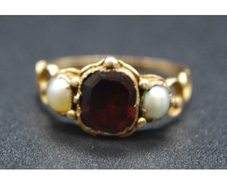 A Victorian yellow metal, garnet and cultured pearl set ring, the octagon cut garnet (with small chip) measuring approx 7.5 x