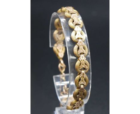 A late 19th century yellow metal bracelet, arranged as reeded circular links united by leaf engraved shaped clips (some later