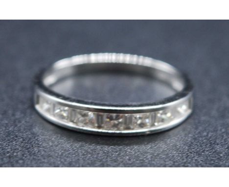 An 18ct white gold diamond half eternity ring, comprising seven Princess cut alternating with eight baguette cut diamonds, al