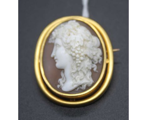 A late Victorian carved shell cameo brooch depicting a profile portrait of a maiden with fruiting vines in her hair, 28x23mm,