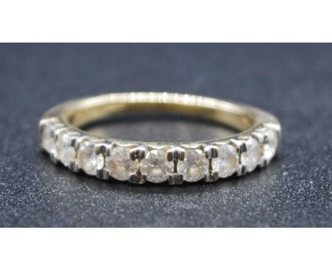 A 9ct yellow and white gold diamond half eternity ring, featuring nine round brilliant cut diamonds in claw settings, diamond