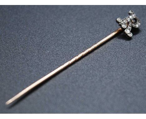 A yellow metal initial R stick-pin set with sixteen rose cut diamonds, diameters between approx 0.8 and 1.5mm, total weight e