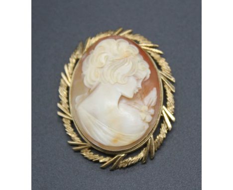 A modern carved shell cameo brooch depicting profile portrait of a young girl with a flower upon her shoulder, 39x30mm, in 9c